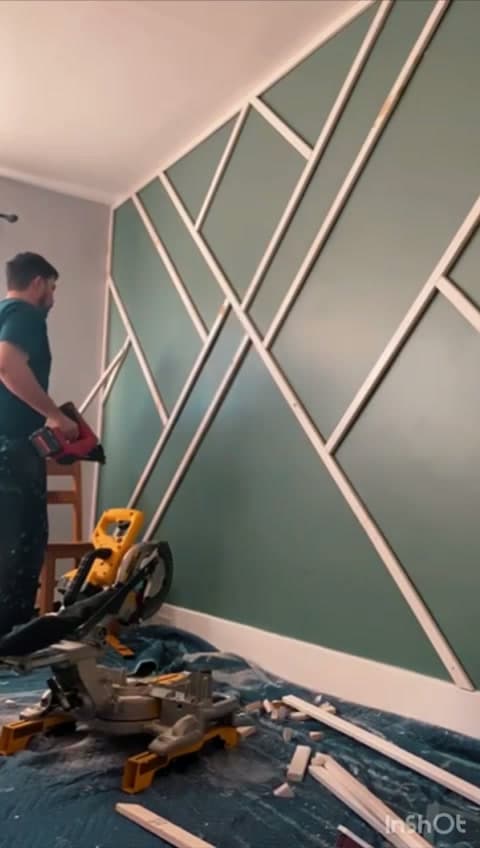 Painter taping and rolling a geometric accent wall in a Worcester area living room